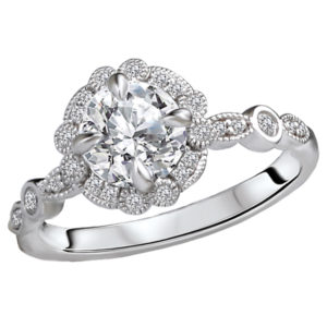 This bridal ring showcases a shank and scalloped round halo lined with sparkling diamonds set in high polished 14kt white gold accented with milgrain detail. (D 1/6 carat total weight) This ring is a SEMI-MOUNT and it comes with NO CENTER STONE as shown but it will accommodate a 6.5mm round center stone.