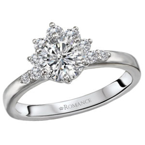This 14kt white gold semi-mount engagement ring has a stunning half halo of round diamonds with additional accent diamonds on either side of the center setting that will accommodate a 6.5mm round diamond. (D 1/4 carat total weight)