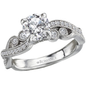 This 14kt white gold semi-mount engagement ring has elegant paisley insired milgrain design along with a fancy peg head setting that will accommodate a 6.5mm round diamond. (D 1/5 carat total weight)