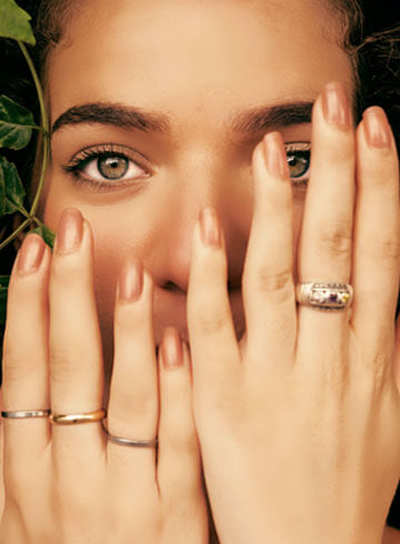 Elegant woman showcasing a collection of stylish jewelry including rings and a ring, promoting Taylor Made Jewelry's handcrafted and customizable jewelry pieces. Perfect for jewelry lovers and gifts.